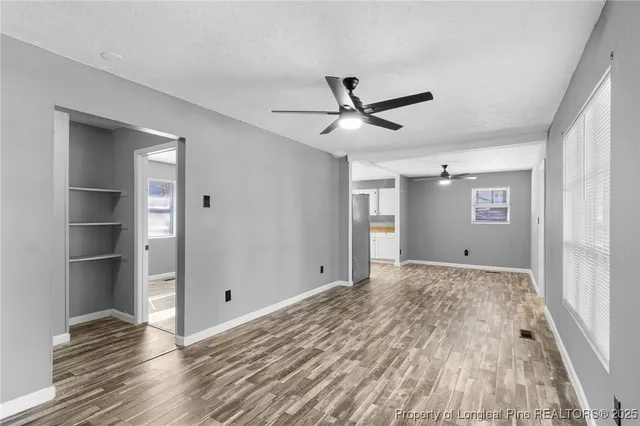 a view of empty room with wooden floor and window