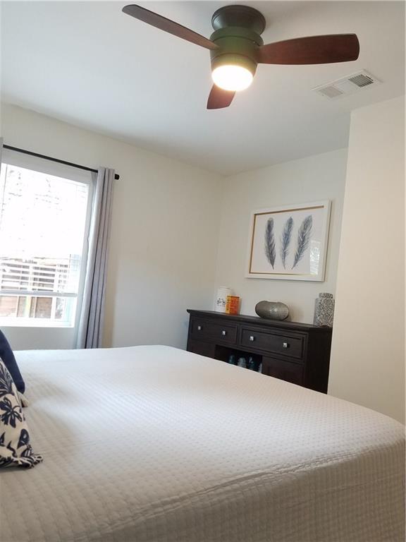 5405 Hudson Street Austin, TX 78721 - Photo 26 of 37 A comforting bedroom with a well-lit ceiling fan and natural illumination from a wide window.