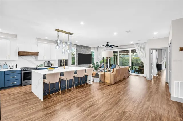 a kitchen with stainless steel appliances a table chairs and a refrigerator