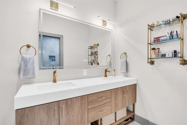 a en suite bathroom with a granite countertop sink and a window