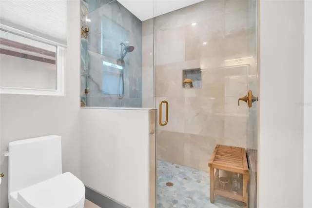 a bedroom with a bed and a flat tv screen on dresser