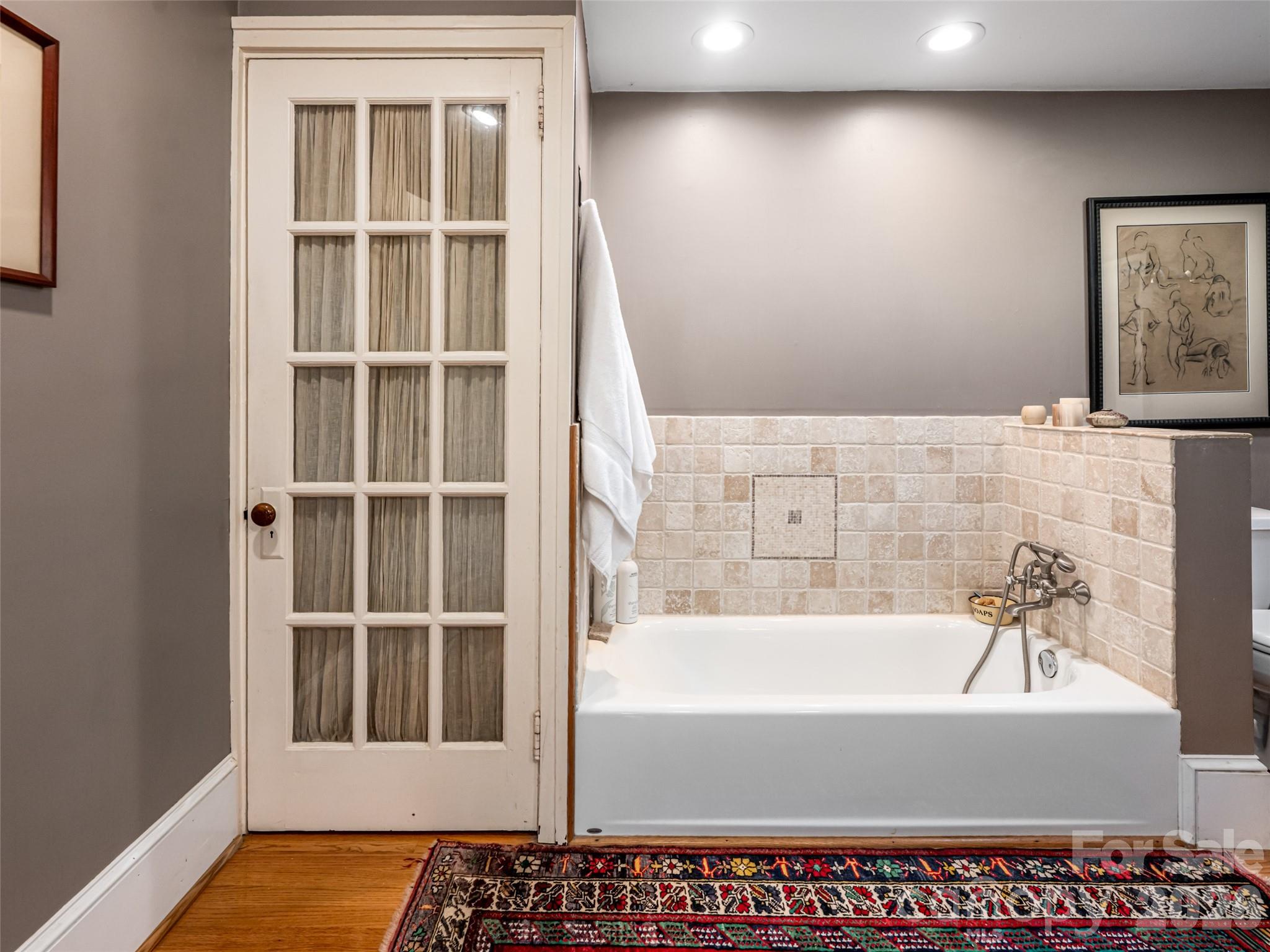352 Justice Ridge Road Candler, NC 28715 - Photo 24 of 48 a bathroom with a bathtub and next to a window