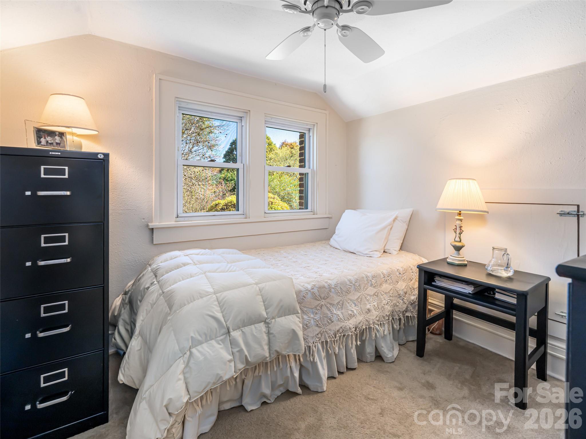 352 Justice Ridge Road Candler, NC 28715 - Photo 28 of 48 a bedroom with a bed and a chandelier