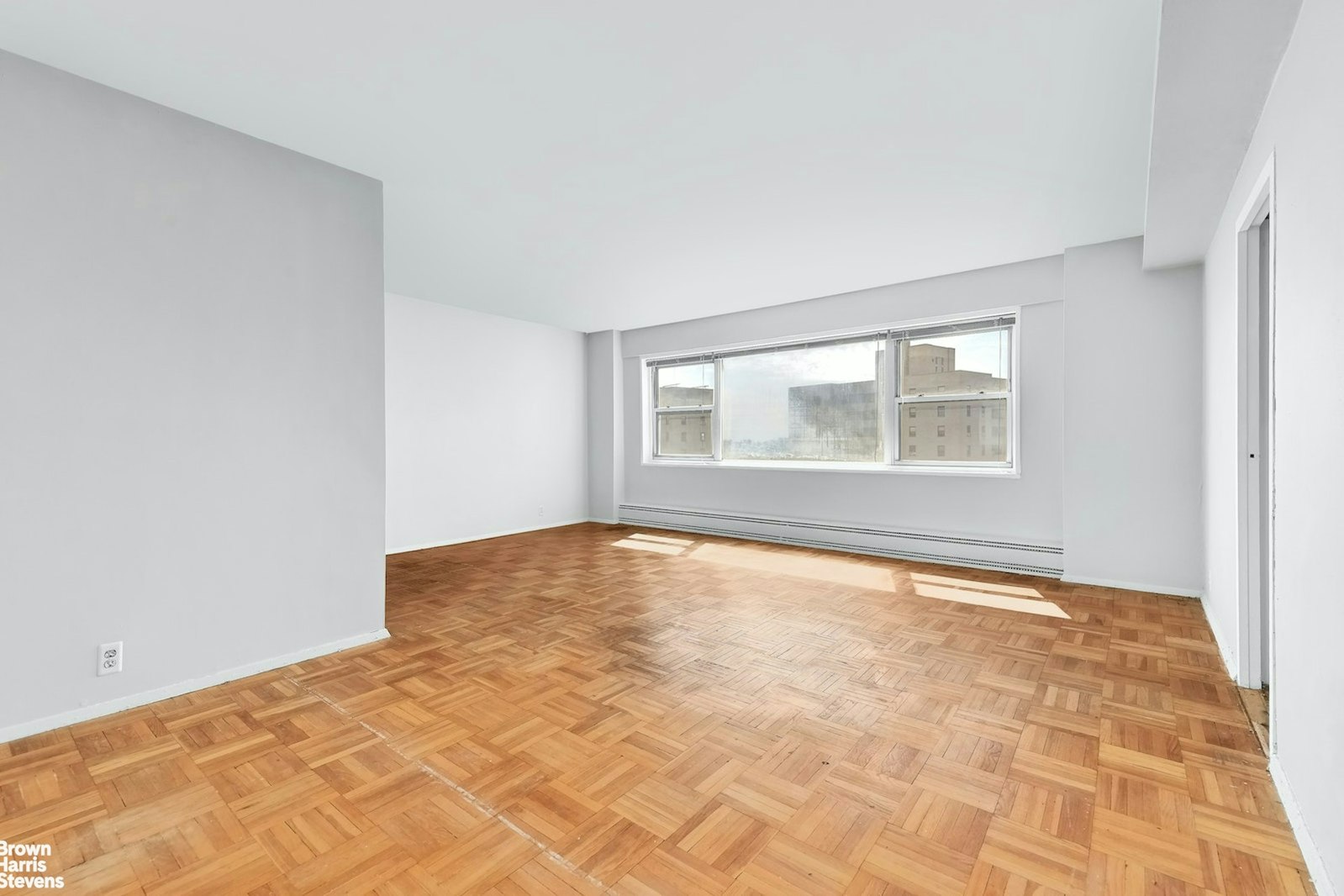 a view of empty room with wooden floor