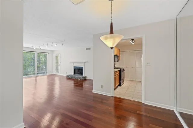a view of empty room with wooden floor and fireplace