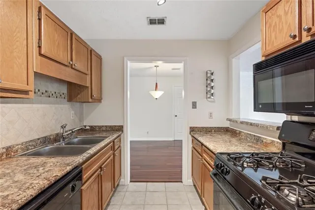 a kitchen with granite countertop a sink stove and cabinets