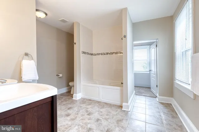 a bathroom with a tub shower and sink