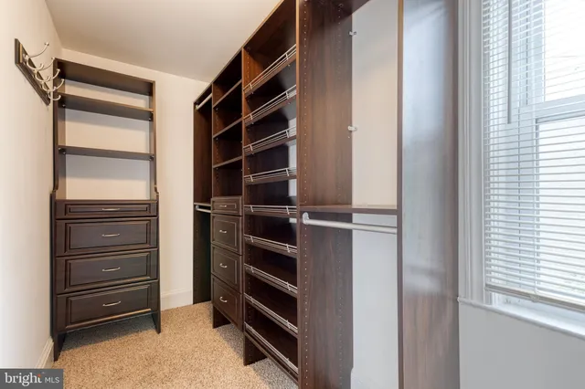 a view of walk in closet with clothes