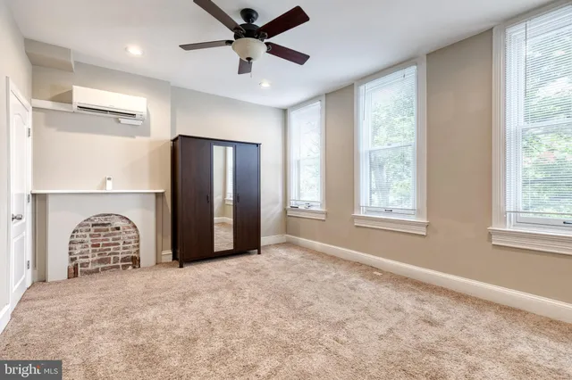 a view of a livingroom with a chandelier fan and windows