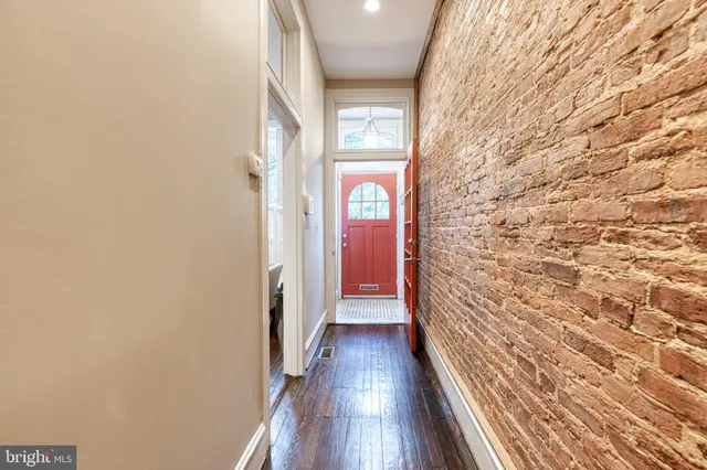 a view of a hallway with wooden floor and a window