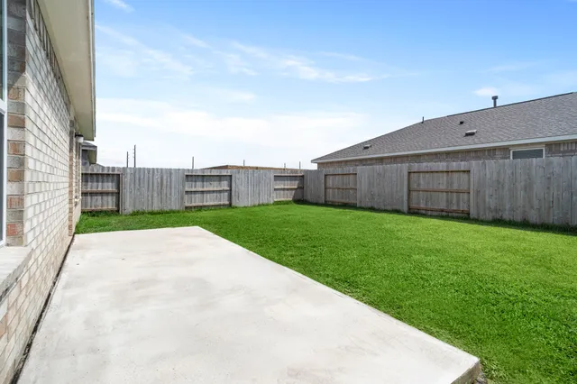 a view of a backyard with wooden fence