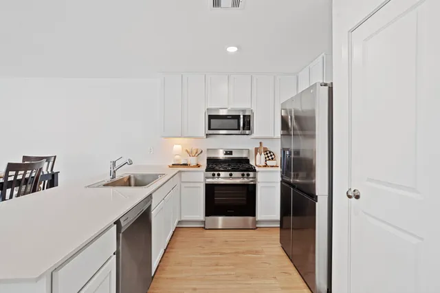 a kitchen with refrigerator a sink and a stove