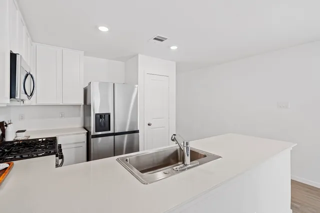 a kitchen with kitchen island a refrigerator sink and stove