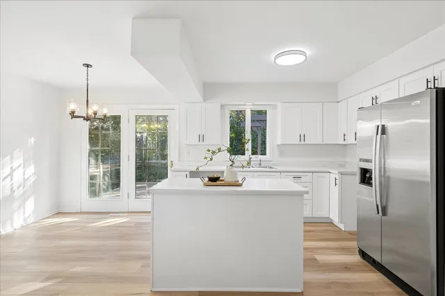 a kitchen with kitchen island a sink appliances and cabinets