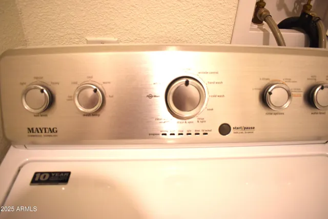 a kitchen with stainless steel appliances granite countertop a refrigerator a sink dishwasher a stove with white cabinets and wooden floor