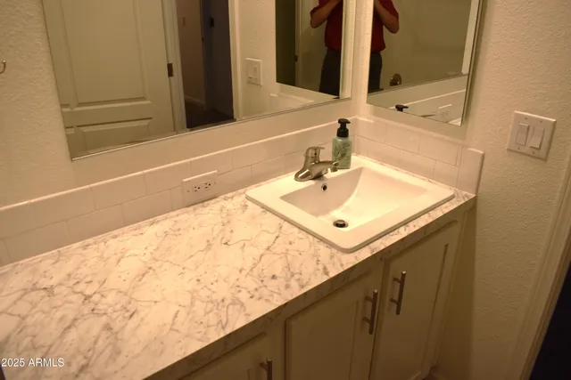 a kitchen with a sink a stove a refrigerator and chairs