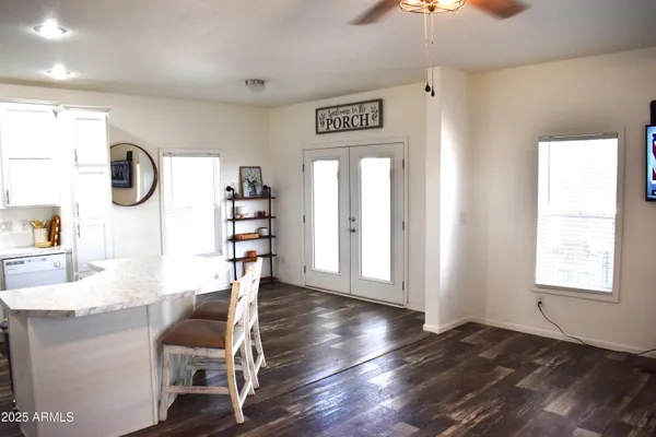 a view of an empty room with window and wooden floor