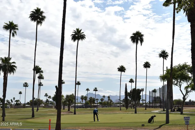 a kitchen with granite countertop a stove a refrigerator a sink and a dining table with wooden floor