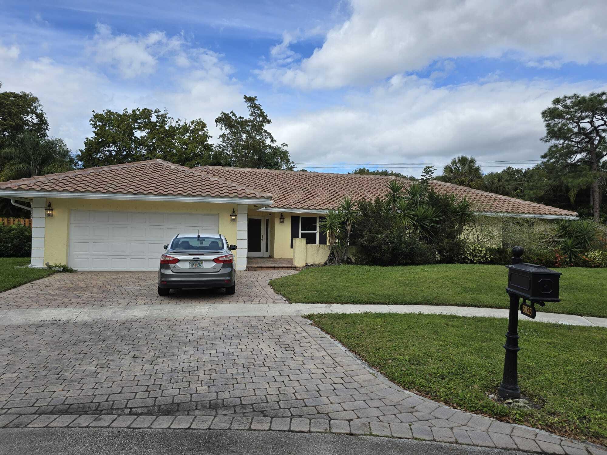 6935 Corto Circle Boca Raton, FL 33433 - Photo 2 of 2 a white house with a yard and a garage