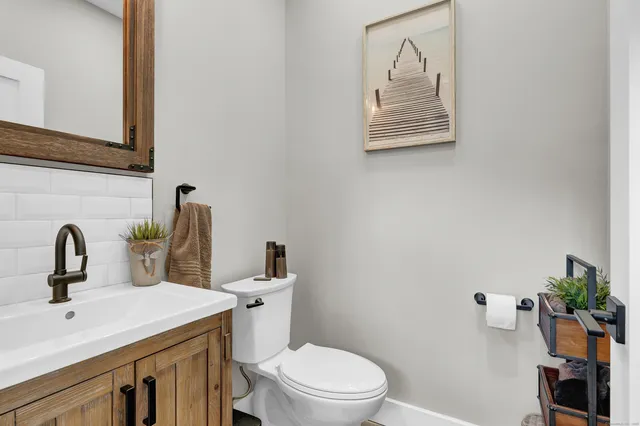 a spacious bathroom with a double vanity sink a mirror and a toilet