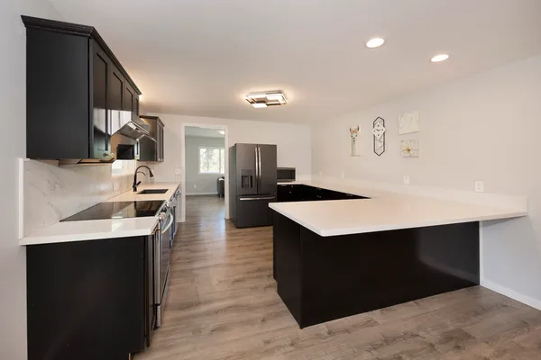a kitchen with a sink refrigerator and cabinets