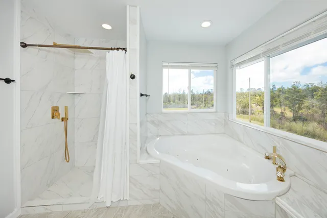 a white bath tub sitting next to a shower