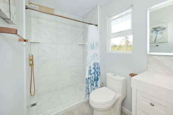 a white toilet sitting next to a bath tub shower