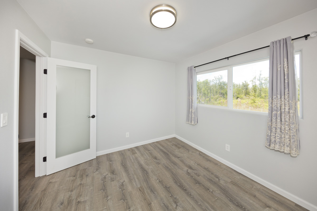 11-2420 Ohialani Road Mountain View, HI 96771 - Photo 24 of 30 a view of an empty room with wooden floor and windows
