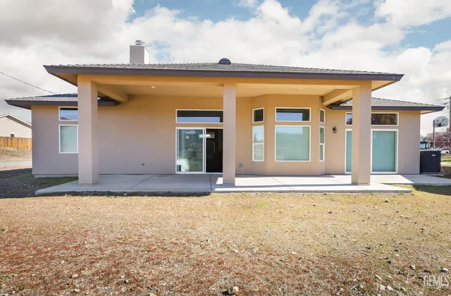 a view of a house with a swimming pool and sitting area