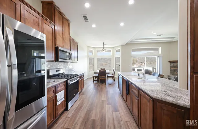 a kitchen with stainless steel appliances granite countertop a stove refrigerator and cabinets