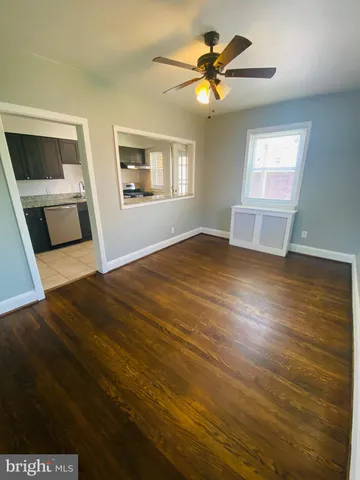 a view of a bedroom with wooden floor and a window