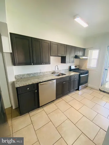 a kitchen with stainless steel appliances a sink a stove a refrigerator cabinets and a counter top space