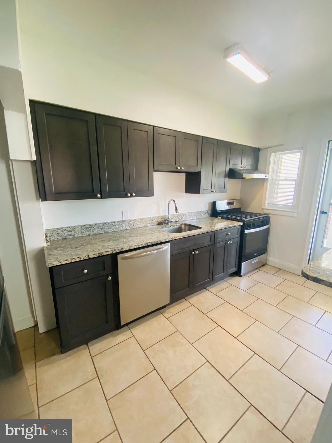 2504 Liberty Parkway Dundalk, MD 21222 - Photo 7 of 21 a kitchen with stainless steel appliances a sink a stove a refrigerator cabinets and a counter top space