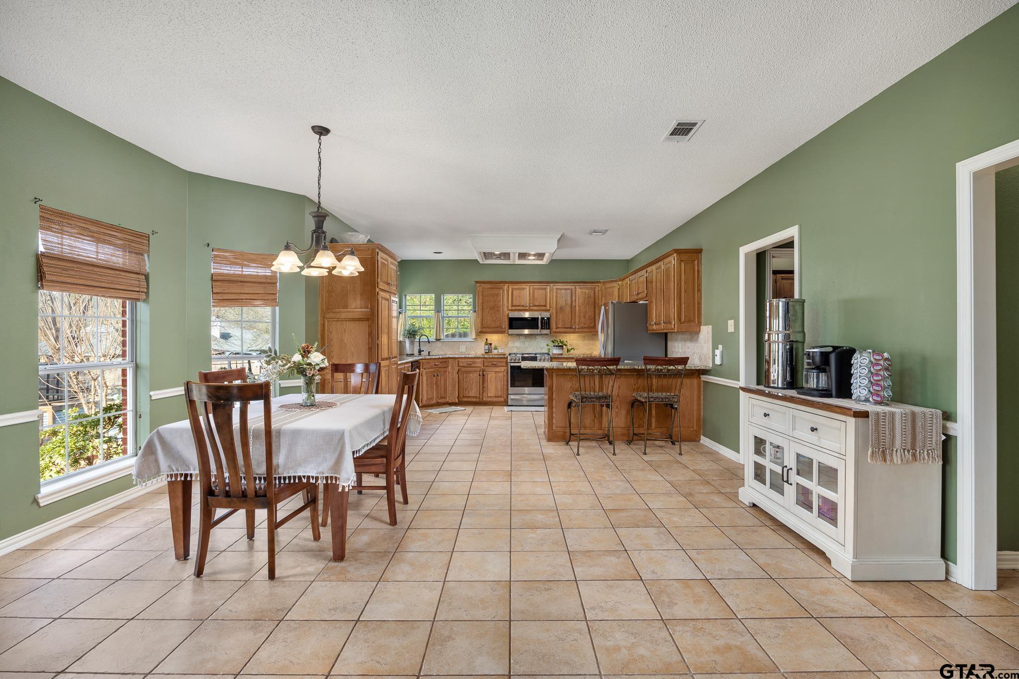 18344 Springmill Court Flint, TX 75762 - Photo 13 of 45 a kitchen with stainless steel appliances granite countertop a stove a sink dishwasher a dining table and chairs with wooden floor