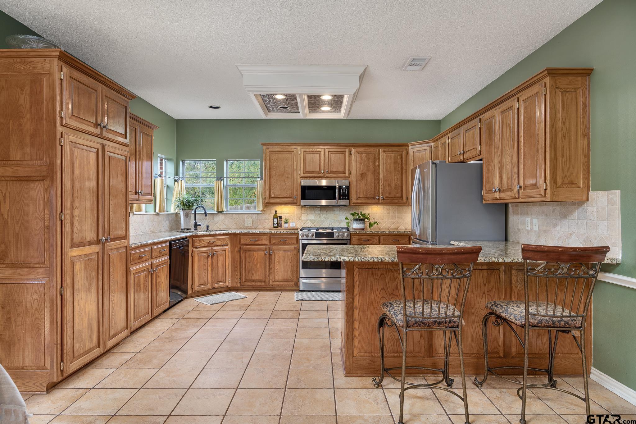 18344 Springmill Court Flint, TX 75762 - Photo 15 of 45 a kitchen with stainless steel appliances granite countertop a stove top oven a sink dishwasher and a refrigerator
