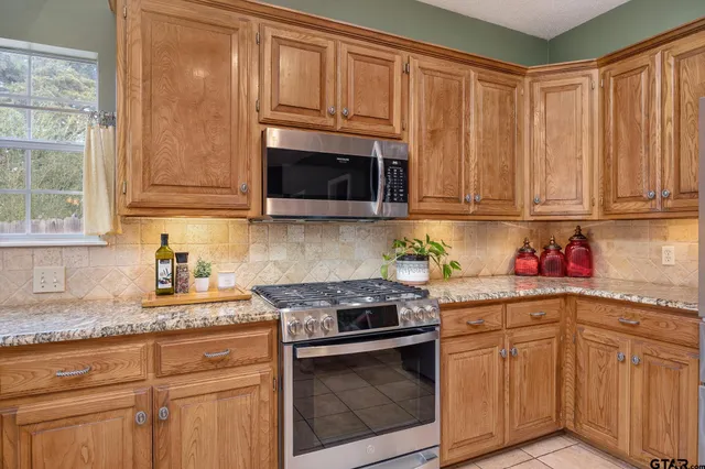 a kitchen with granite countertop cabinets stainless steel appliances and a sink