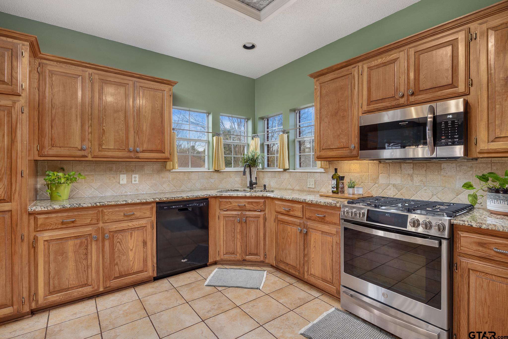 18344 Springmill Court Flint, TX 75762 - Photo 18 of 45 a kitchen with stainless steel appliances granite countertop a stove sink microwave and cabinets