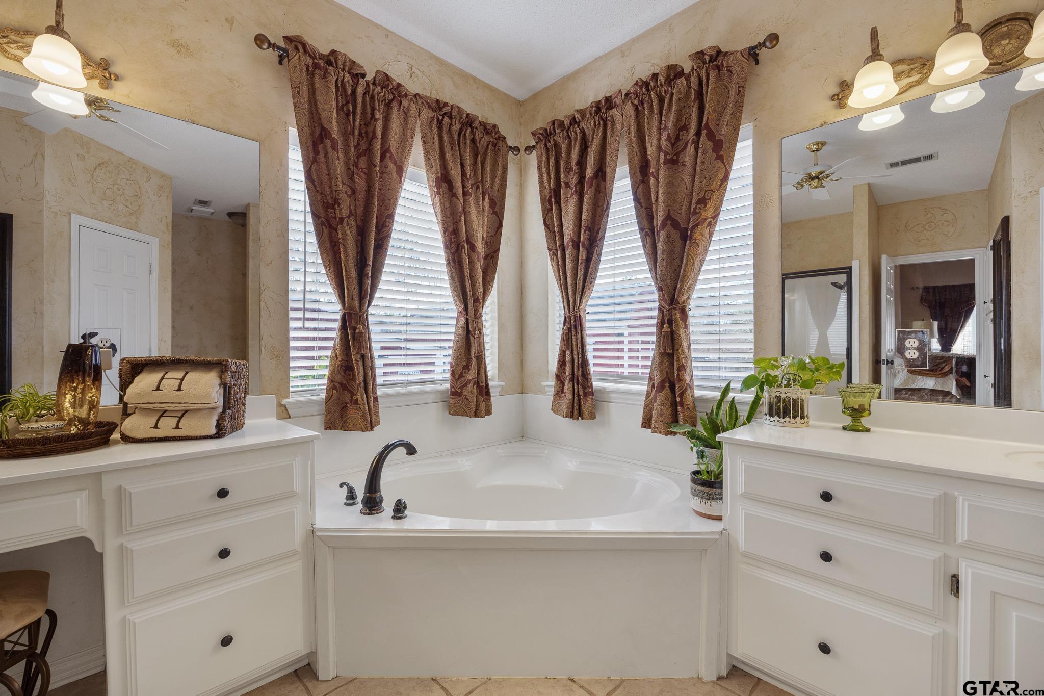 18344 Springmill Court Flint, TX 75762 - Photo 26 of 45 a bathroom with double vanity sink a mirror and a bathtub