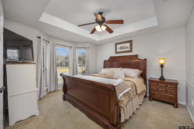 a spacious bedroom with a bed and a chandelier