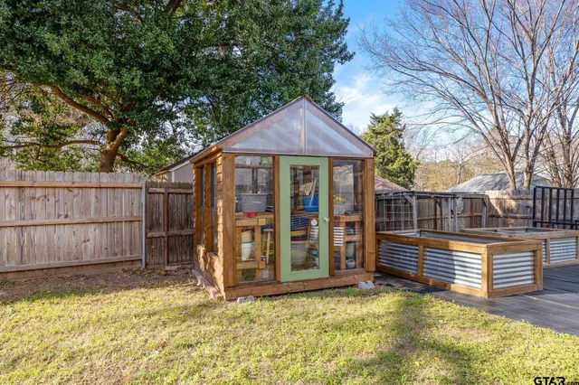 a view of a house with wooden fence in a backyard