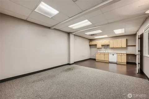 a view of a kitchen with refrigerator and white cabinets