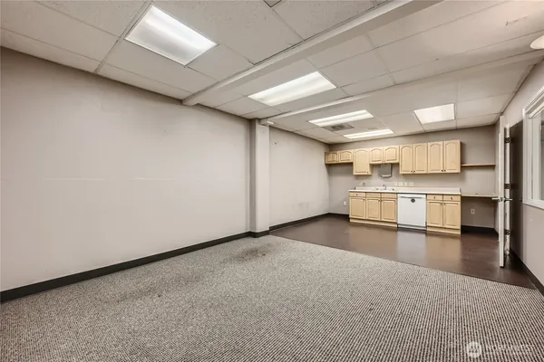 a view of a kitchen with refrigerator and white cabinets