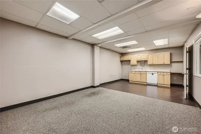 a view of a kitchen with refrigerator and white cabinets