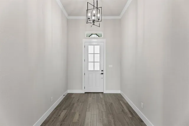 a view of a kitchen and an empty room with a fireplace