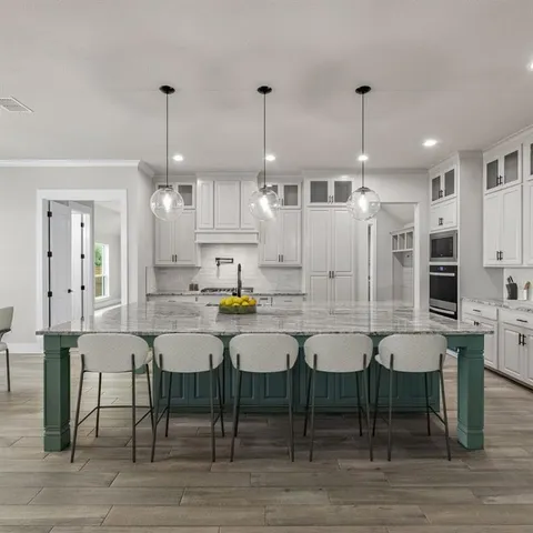 a kitchen with kitchen island a counter space a sink appliances and cabinets