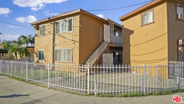 a view of a house with a small yard and wooden floor and fence