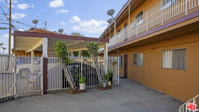 a view of a house with stairs and wooden fence