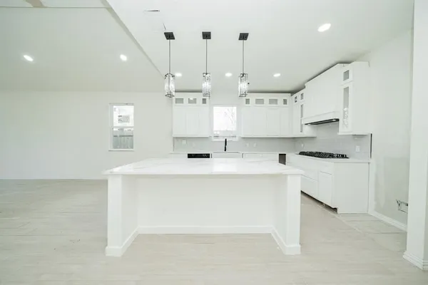 a kitchen with kitchen island a sink stainless steel appliances and cabinets