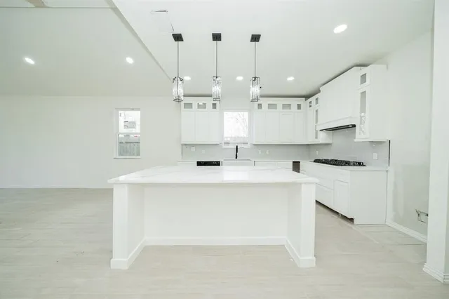 a kitchen with kitchen island a sink stainless steel appliances and cabinets
