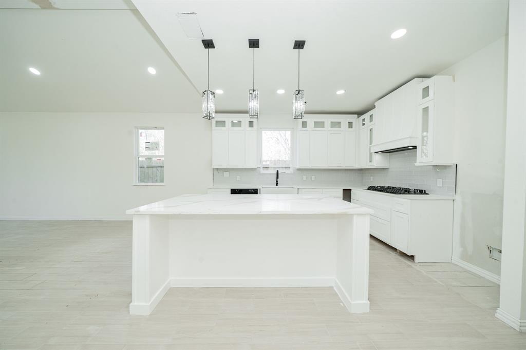 a kitchen with kitchen island a sink stainless steel appliances and cabinets